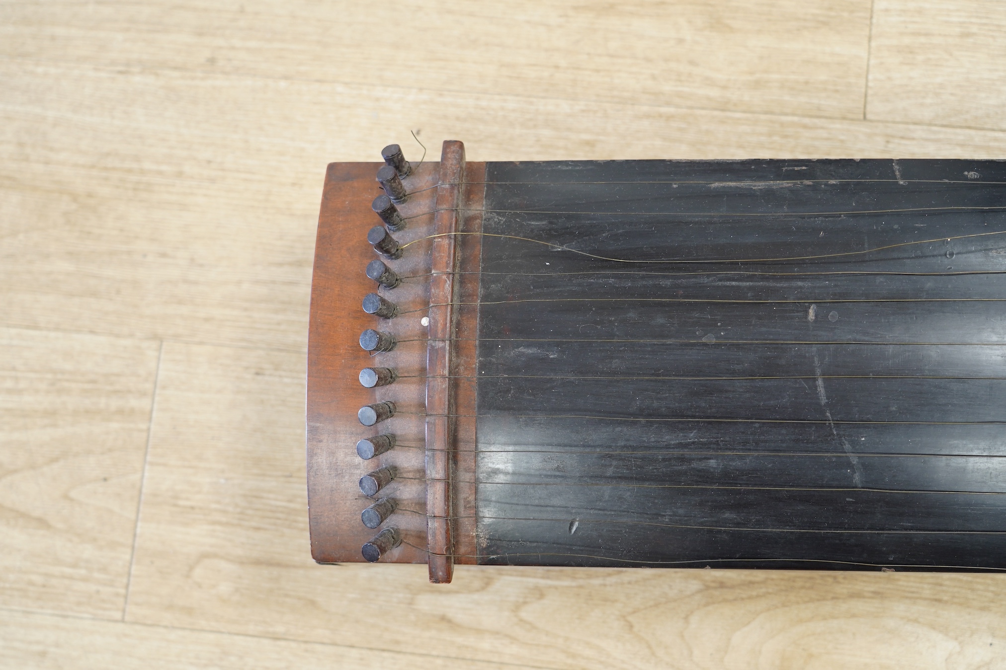 A Japanese Kato musical instrument with spares,19th century, 110cm long. Condition - fair, body of instrument and pegs have damage